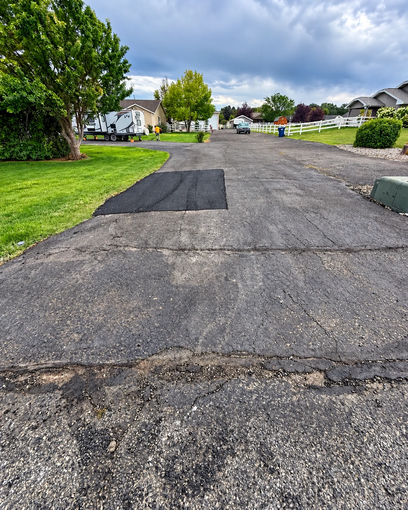 A rectangular asphalt patch beside the surrounding driveway pavement.