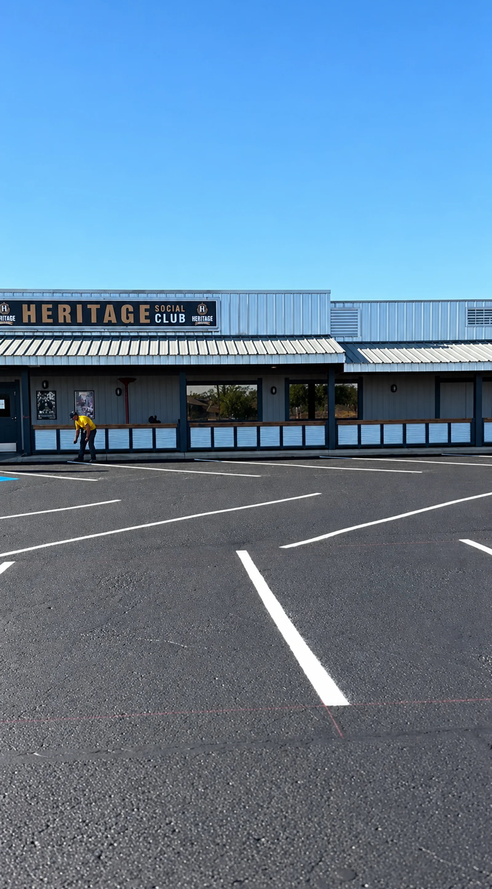 White parking stall lines in front of a commercial building, with a Superior crew member working beside the entrance.