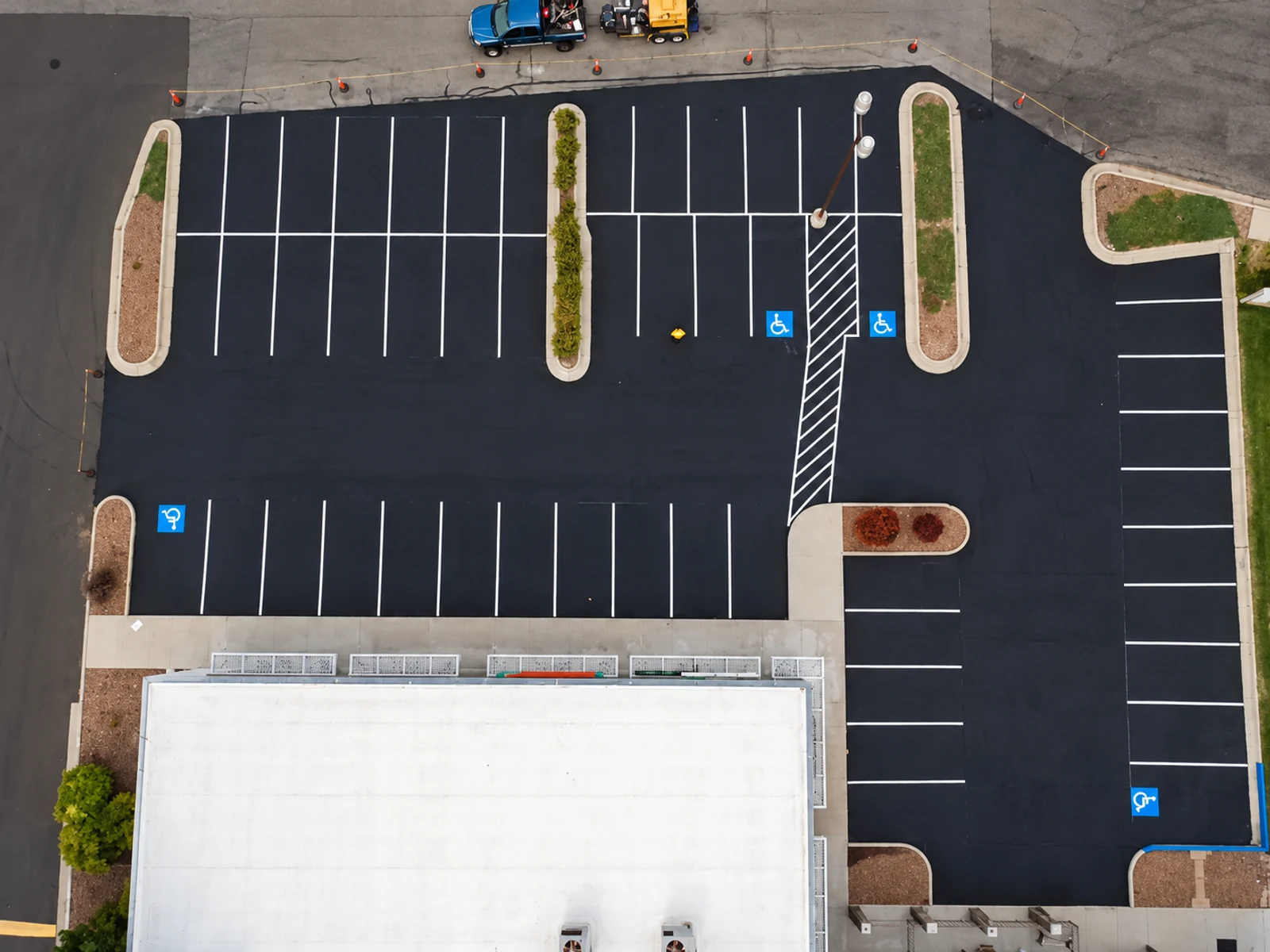 White parking stalls and blue pavement markings viewed from above at a Superior Striping project.